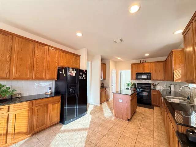 a kitchen with stainless steel appliances granite countertop a refrigerator stove and sink