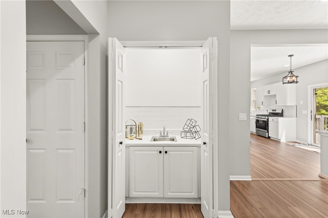 8080 Fair Road Strongsville, OH 44149 - Photo 11 of 50 Indoor wet bar with gas range, wood finished floors, baseboards, and pendant lighting