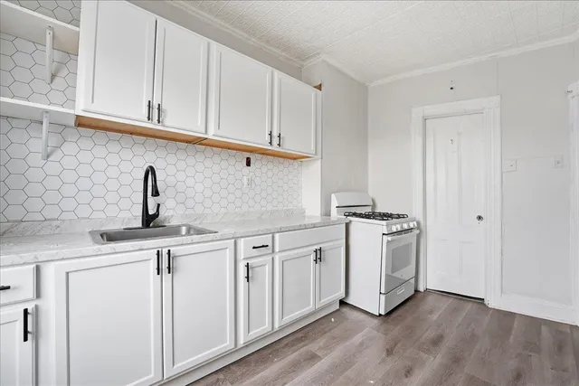 a kitchen with stainless steel appliances granite countertop white cabinets a sink and dishwasher