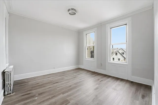an empty room with wooden floor and window