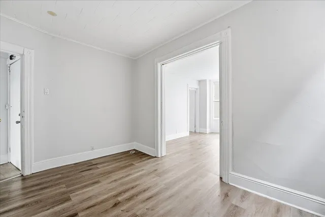 a view of a room with wooden floor and a window