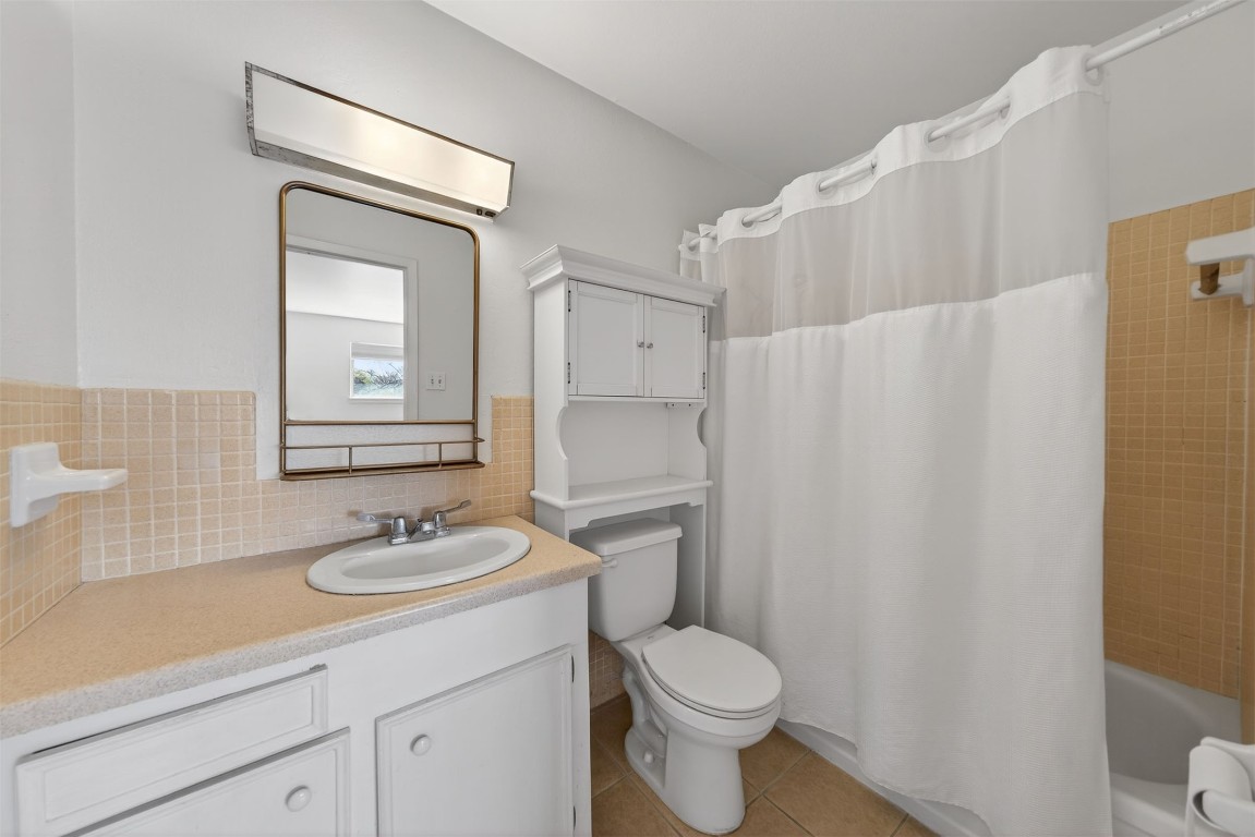7205 Beechnut Street, Unit D Houston, TX 77074 - Photo 13 of 20 a bathroom with a sink a toilet and a mirror