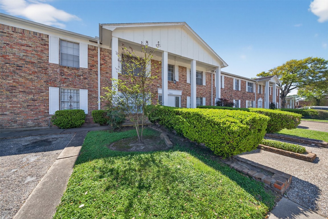 7205 Beechnut Street, Unit D Houston, TX 77074 - Photo 17 of 20 a view of a house with brick walls and a yard with plants