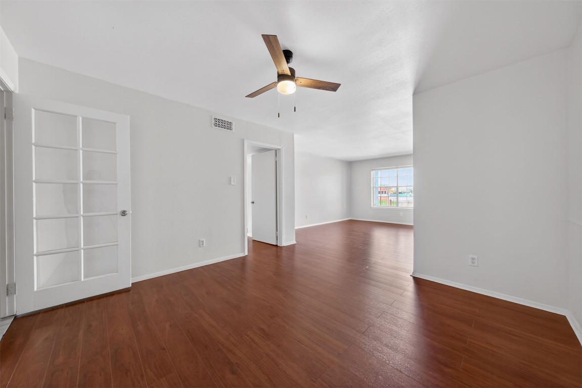 7205 Beechnut Street, Unit D Houston, TX 77074 - Photo 4 of 20 an empty room with wooden floor chandelier fan and windows