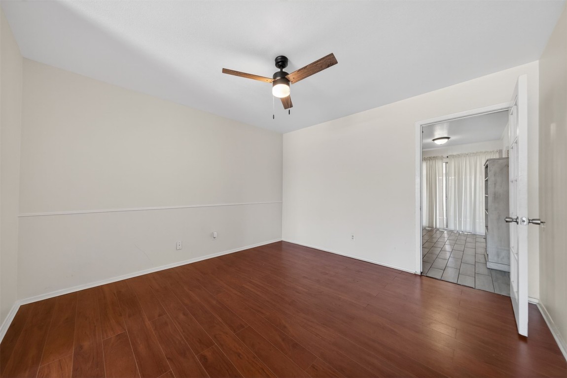 7205 Beechnut Street, Unit D Houston, TX 77074 - Photo 5 of 20 an empty room with wooden floor ceiling fan and windows