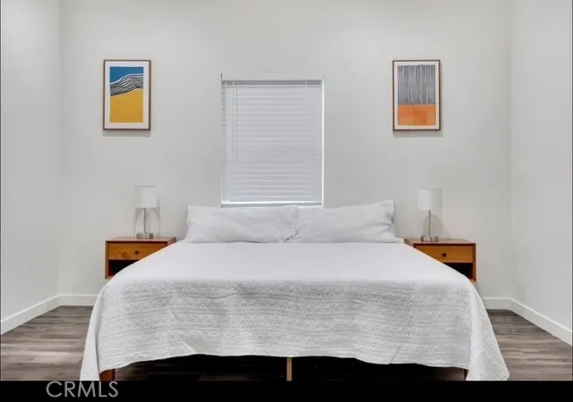 a bedroom with a bed and painting on the wall