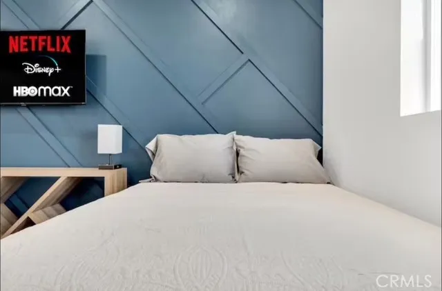 a large bed sitting in a bedroom next to a window