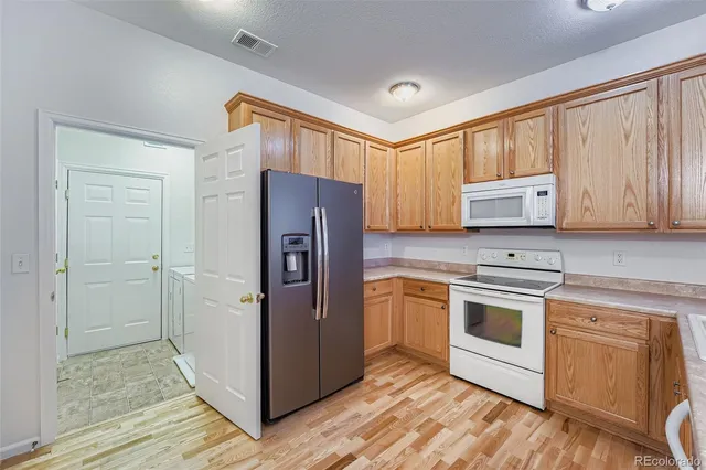 a kitchen with stainless steel appliances granite countertop a refrigerator and a stove top oven