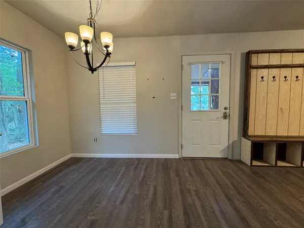 a view of a room with wooden floors and chandelier