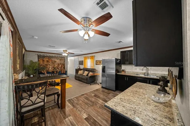 a living room with stainless steel appliances kitchen island granite countertop furniture and a kitchen view