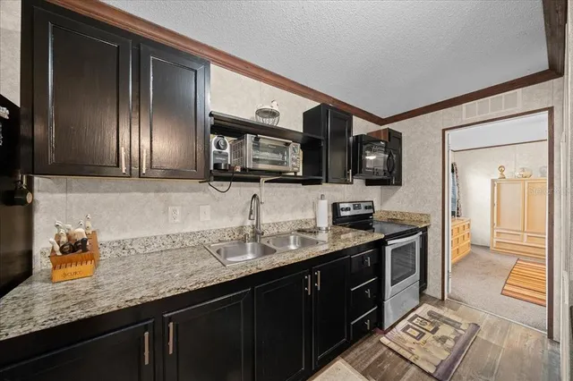 a kitchen with stainless steel appliances granite countertop a sink stove and oven