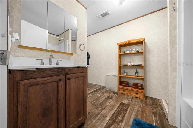 a bathroom with a granite countertop sink toilet mirror vanity and shower