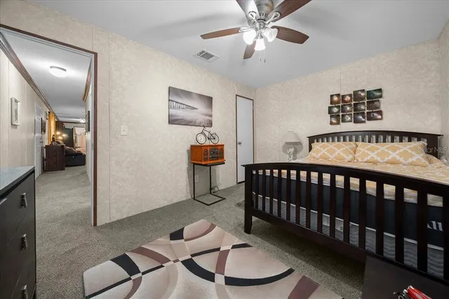 a bedroom with a bed lamp and a potted plant