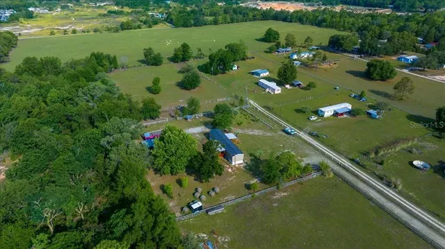 an aerial view of a house with a garden and lake view