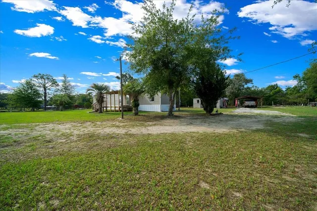 a backyard of a house with lots of green space and fountain