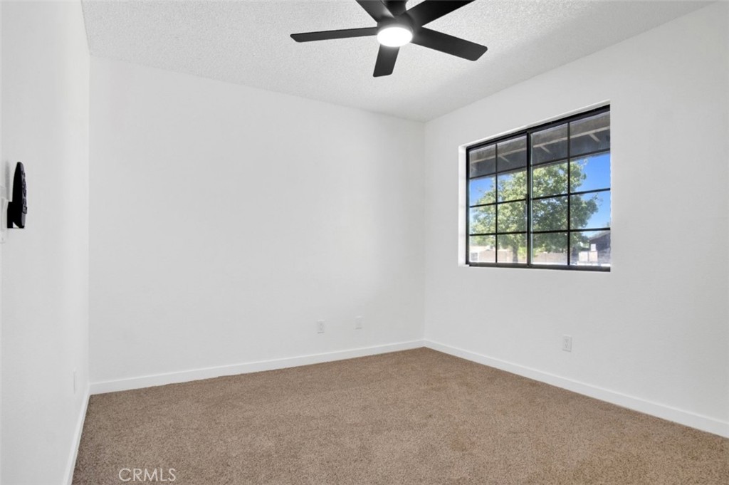 1012 Lightcap Street Lancaster, CA 93535 - Photo 14 of 33 an empty room with a window and a ceiling fan