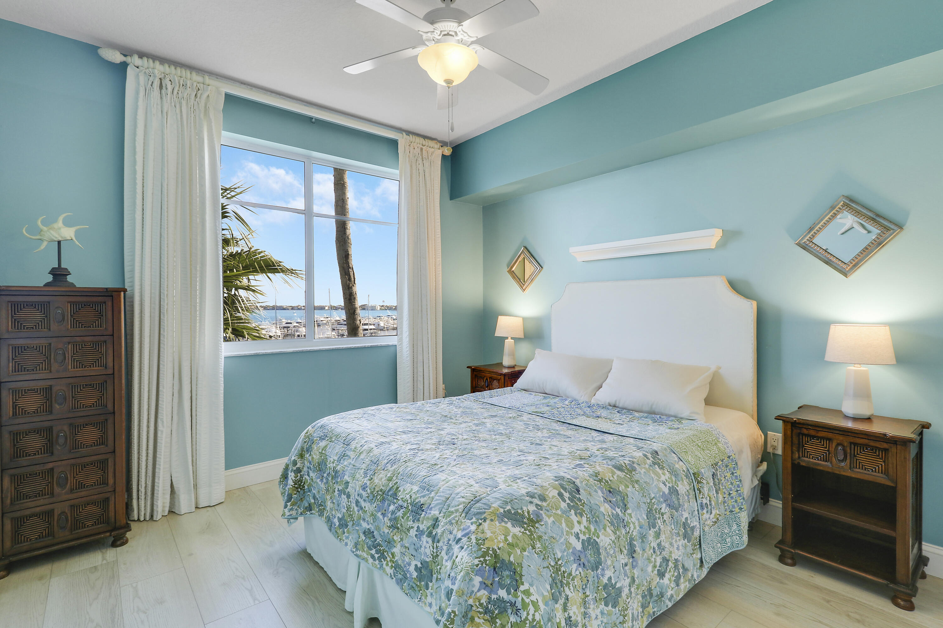 875 Northwest Flagler Avenue, Unit 401 Stuart, FL 34994 - Photo 23 of 36 a bedroom with a large bed and a chandelier