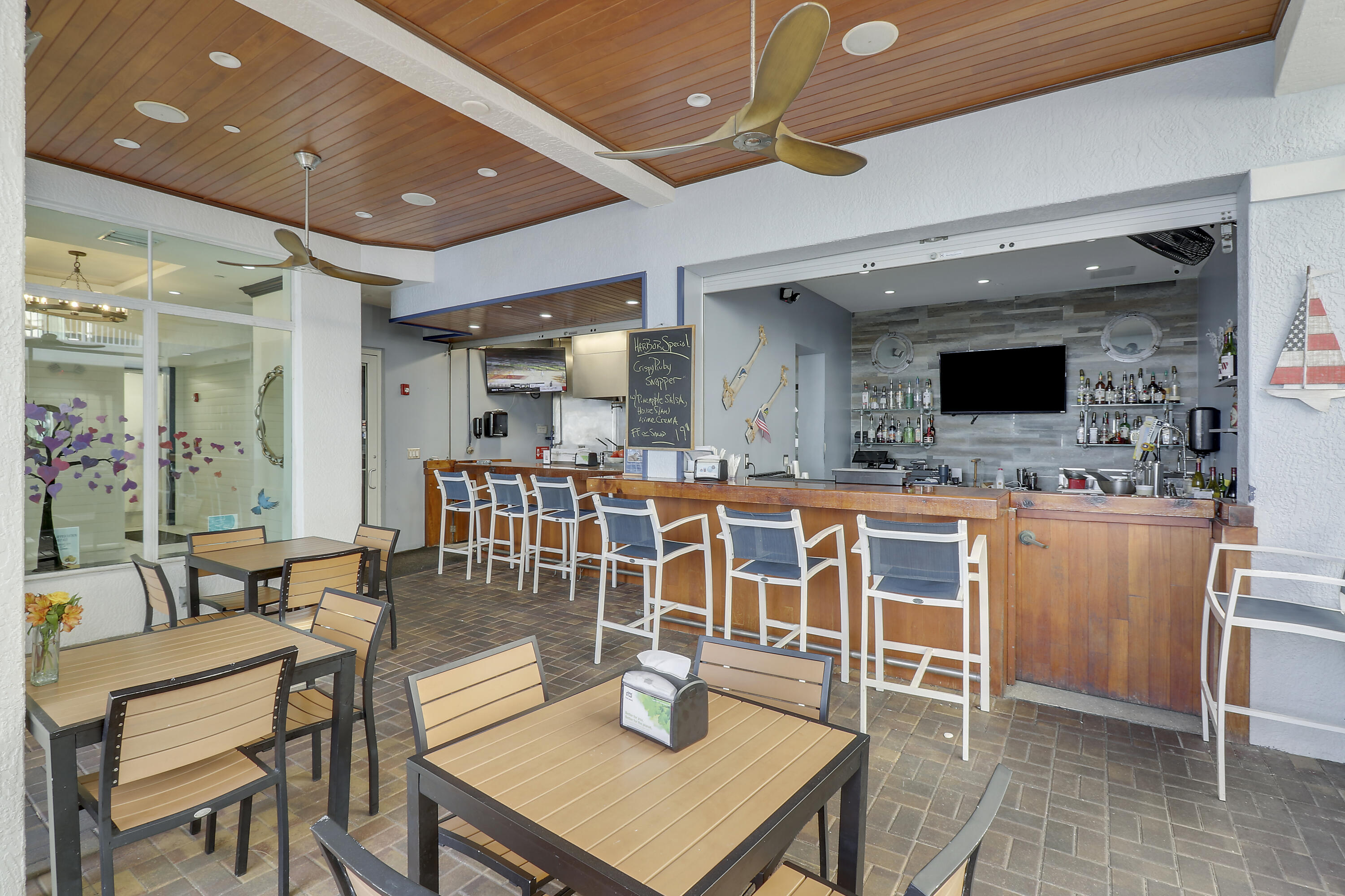 875 Northwest Flagler Avenue, Unit 401 Stuart, FL 34994 - Photo 35 of 36 a kitchen with stainless steel appliances kitchen island granite countertop a table chairs and a sink
