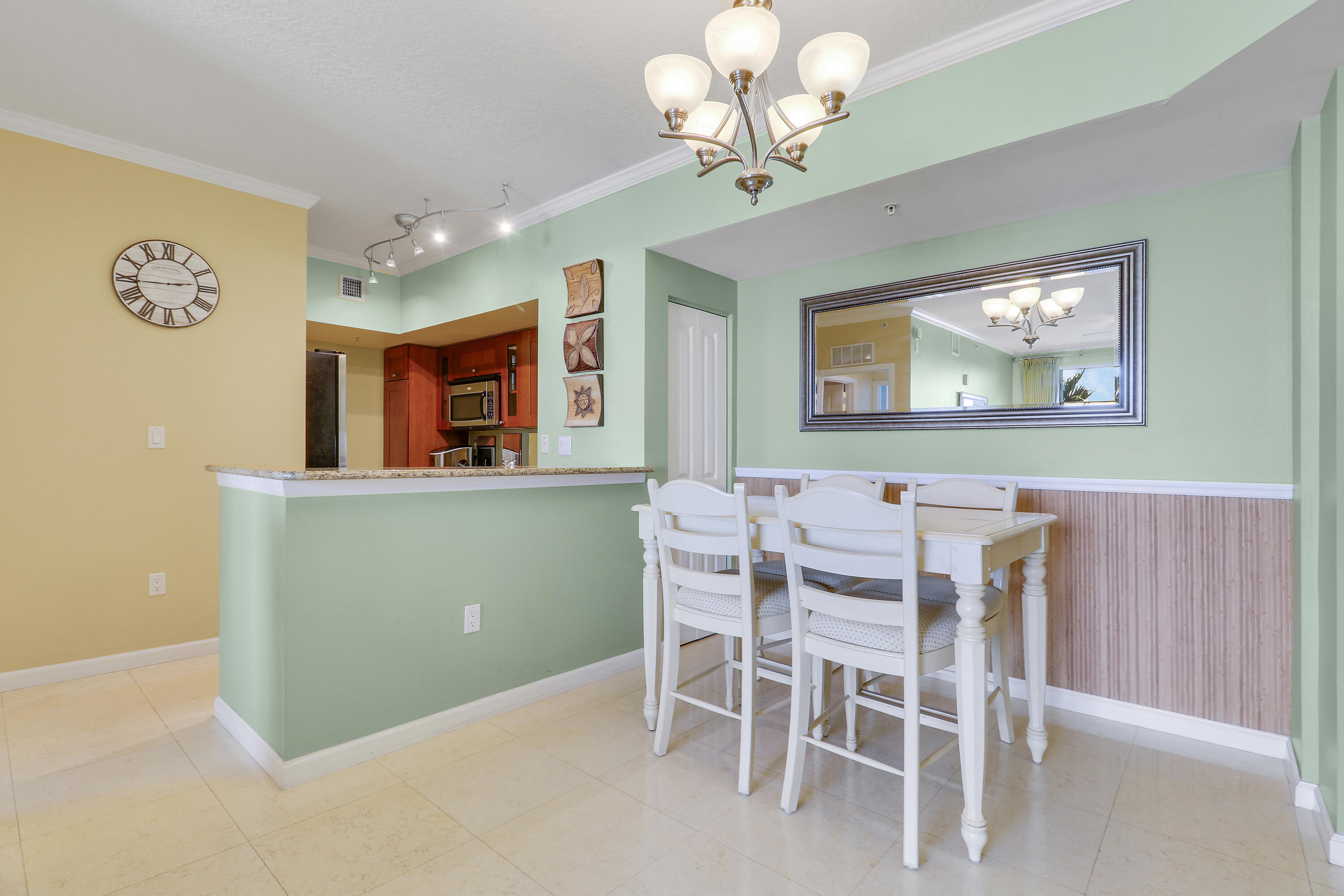 875 Northwest Flagler Avenue, Unit 401 Stuart, FL 34994 - Photo 6 of 36 a view of a dining room with furniture and a chandelier fan