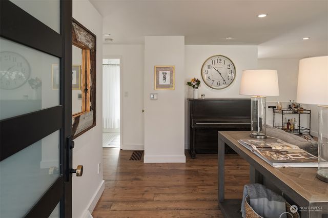 a kitchen with a refrigerator a stove top oven a clock and a window