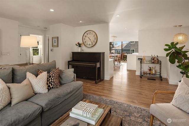 a living room with furniture a clock on wall and a table