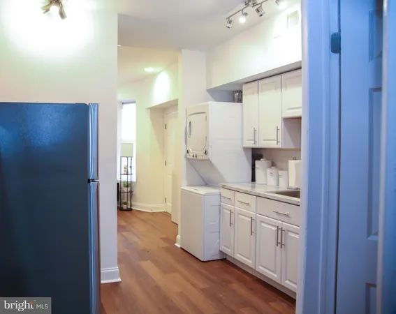 a view of a kitchen with fridge and wooden floor