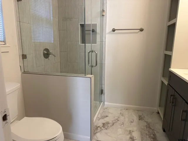 a bathroom with a toilet and shower