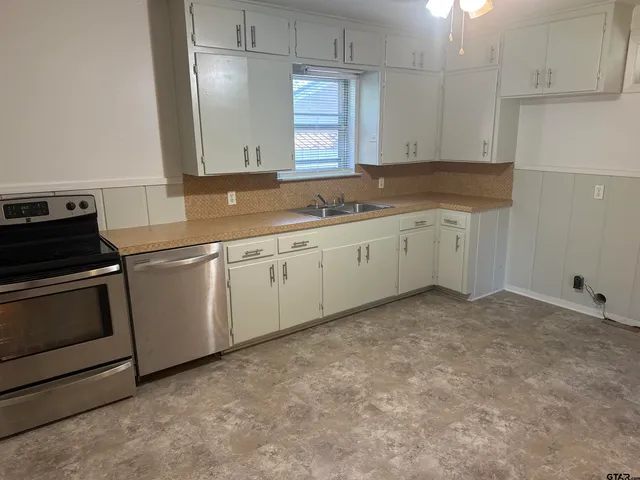 a kitchen with granite countertop white cabinets and white appliances