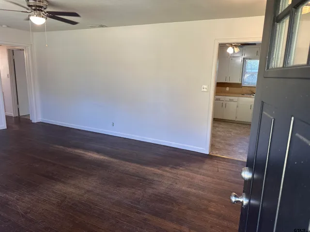a view of a hallway with wooden floor and a sink