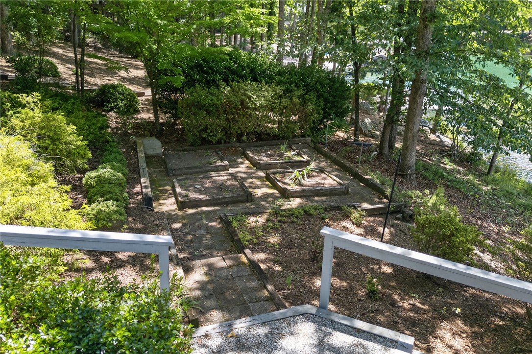 9 Lookout Lane Salem, SC 29676 - Photo 37 of 46 A tiered landscape with garden beds leads to the tranquil lakefront through a natural wooded setting.