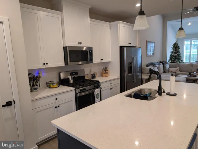a kitchen with granite countertop a refrigerator stove and sink