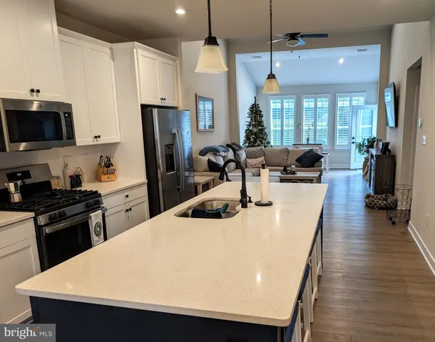 a kitchen with sink a refrigerator and chairs