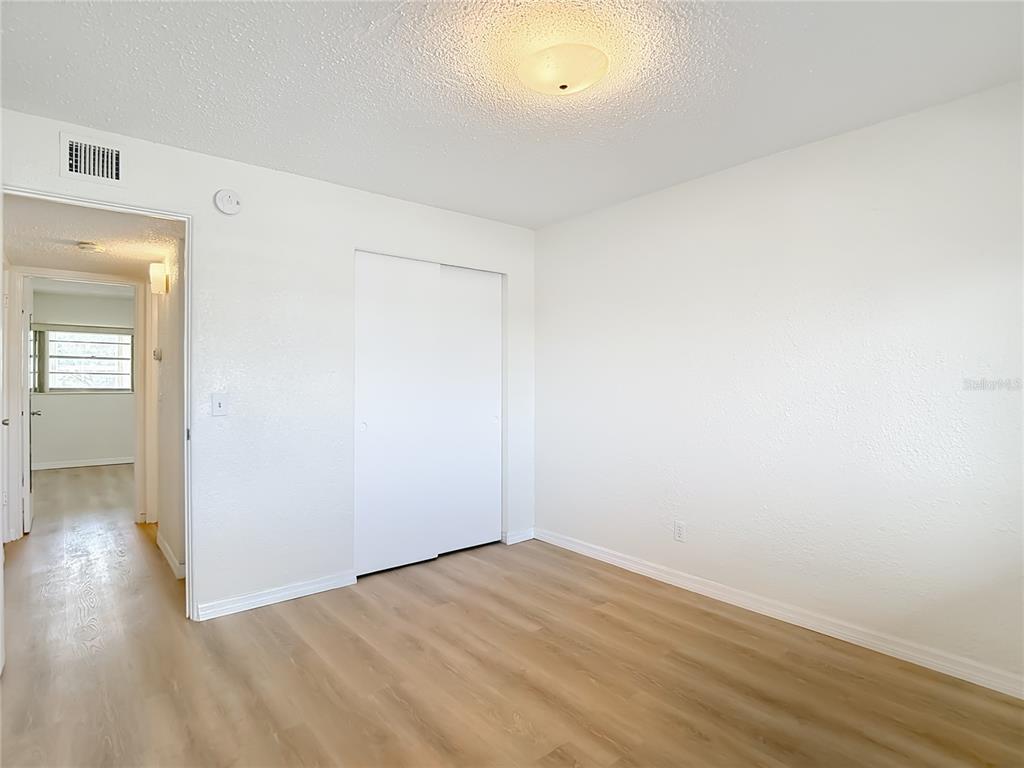 2461 Canadian Way, Unit 45 Clearwater, FL 33763 - Photo 24 of 33 an empty room with wooden floor and windows