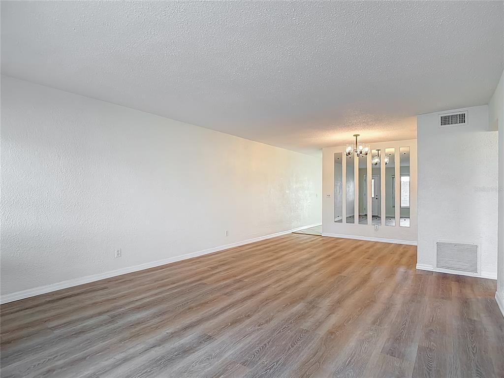 2461 Canadian Way, Unit 45 Clearwater, FL 33763 - Photo 3 of 33 a view of an empty room with wooden floor and a window