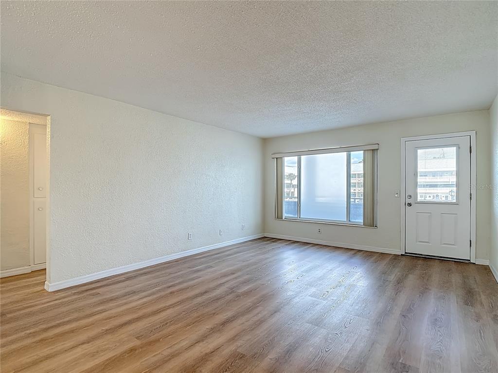2461 Canadian Way, Unit 45 Clearwater, FL 33763 - Photo 5 of 33 a view of an empty room with wooden floor and window