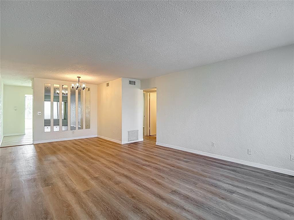 2461 Canadian Way, Unit 45 Clearwater, FL 33763 - Photo 7 of 33 a view of an empty room with wooden floor and a window
