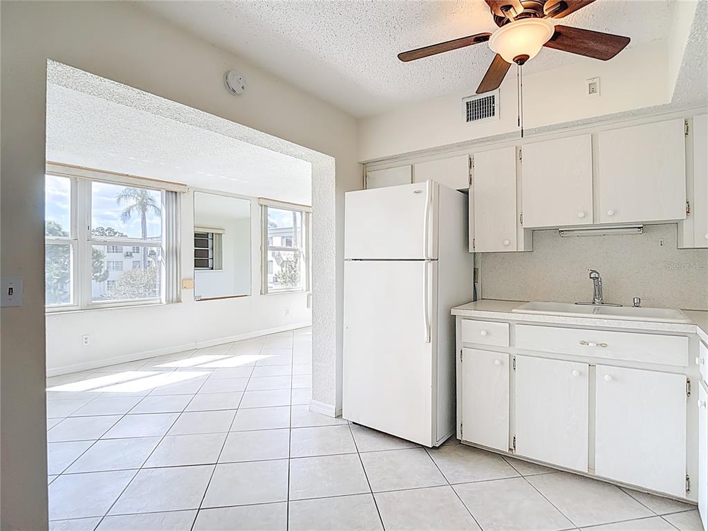2461 Canadian Way, Unit 45 Clearwater, FL 33763 - Photo 10 of 33 a kitchen with a refrigerator a stove top oven and cabinets