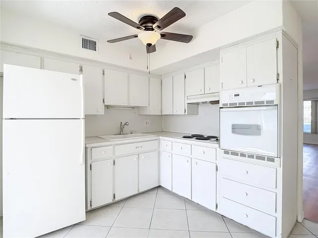 a kitchen with cabinets stainless steel appliances and a refrigerator
