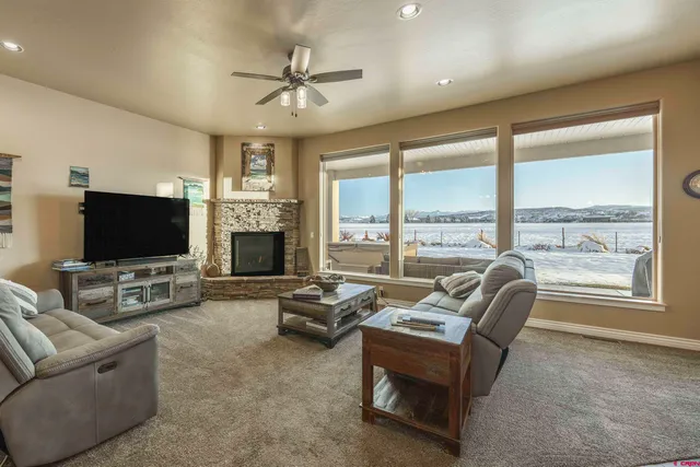 a living room with furniture a flat screen tv and a large window