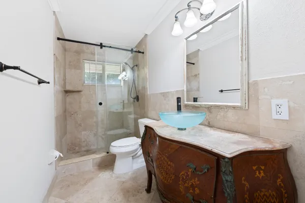 a bathroom with a granite countertop sink a toilet and a mirror