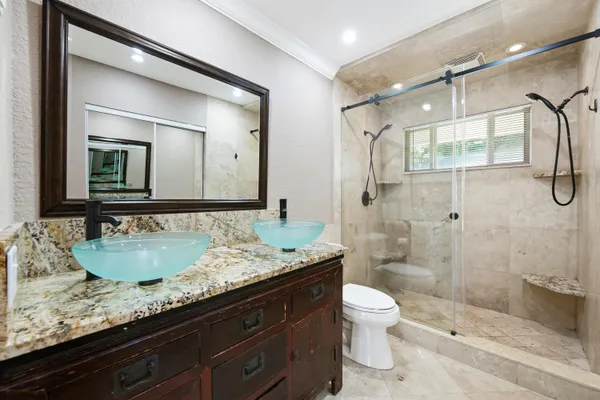 an aerial view of residential houses with outdoor space and trees