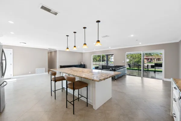 a kitchen with stainless steel appliances granite countertop a refrigerator a stove and a sink