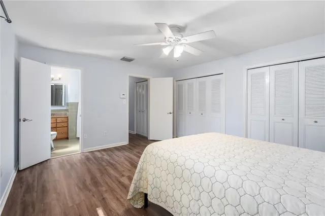 a bedroom with a bed and closet with wooden floor
