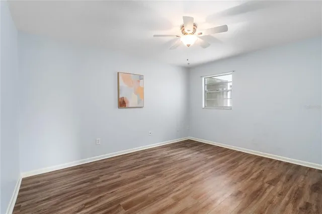a view of a room with wooden floor and a ceiling fan
