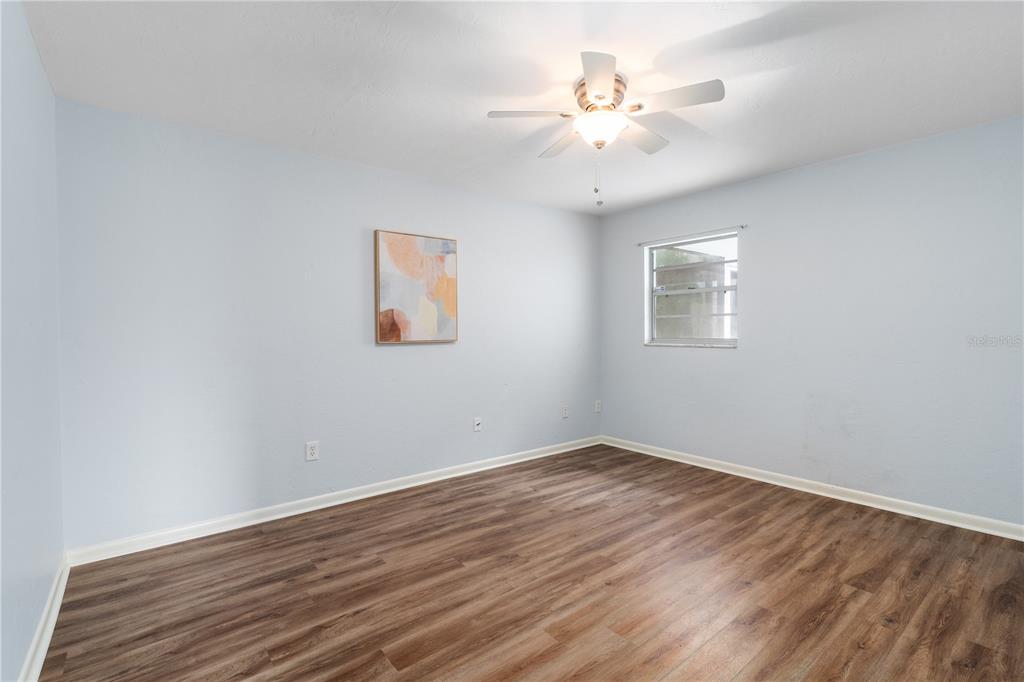 8024 Northwest 2nd Court Gainesville, FL 32607 - Photo 16 of 40 a view of a room with wooden floor and a ceiling fan