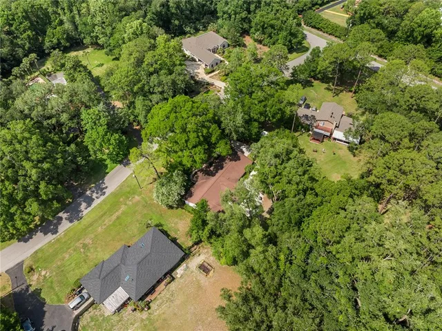 an aerial view of residential house with outdoor space and trees all around