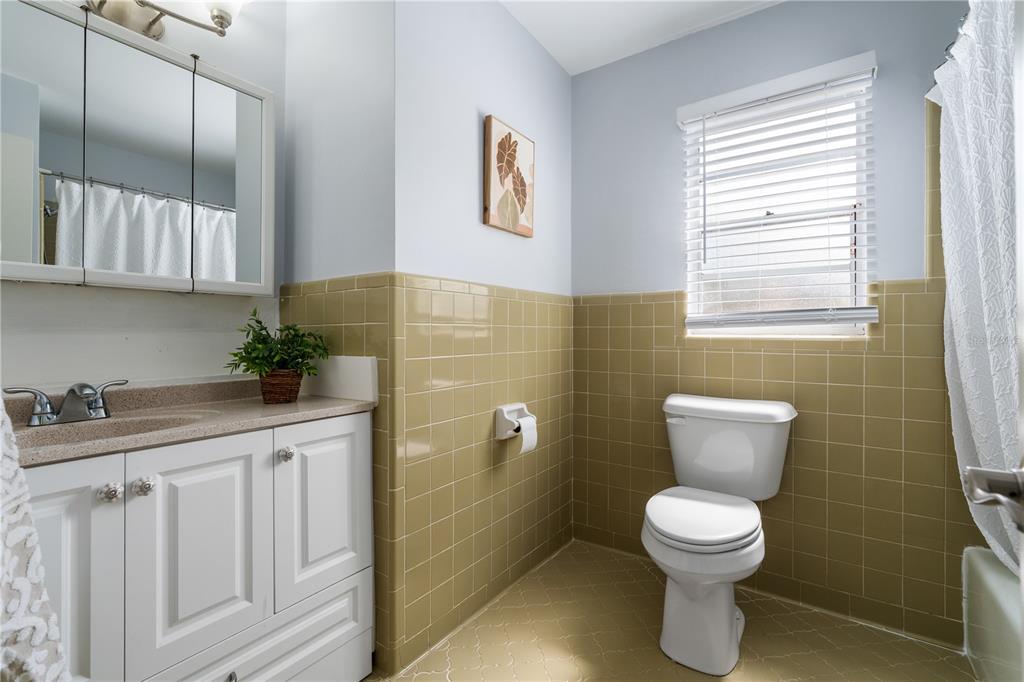 8024 Northwest 2nd Court Gainesville, FL 32607 - Photo 21 of 40 a bathroom with a toilet a sink and mirror