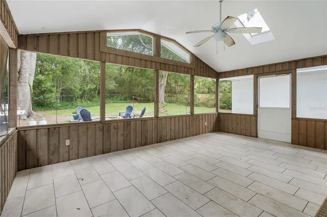 a view of a room with an empty space and large windows