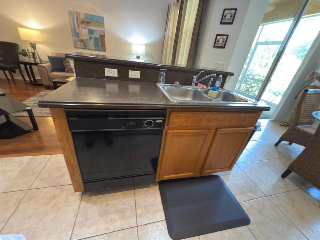 879 Assembly Court Reunion, FL 34747 - Photo 11 of 46 a kitchen with granite countertop a stove a sink and a microwave