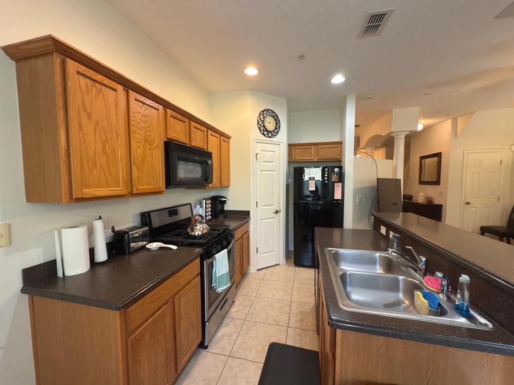 879 Assembly Court Reunion, FL 34747 - Photo 14 of 46 a kitchen with stainless steel appliances granite countertop a sink and cabinets